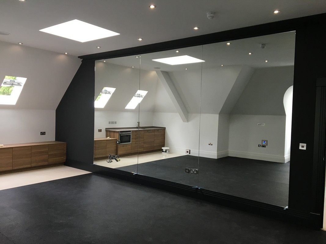 Frameless glass wall dividing loft conversion in Wokingham